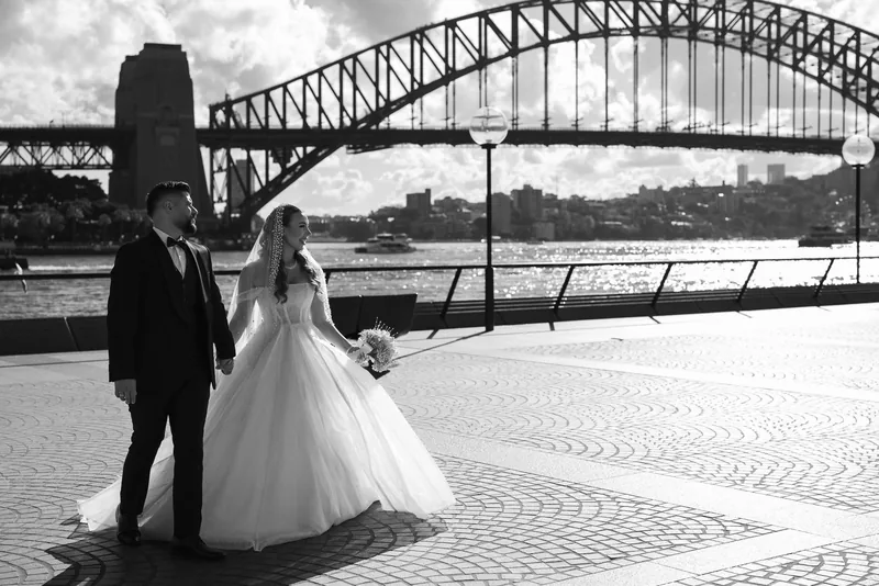 Bride and groom at the Sydney Opera House forecourt with the Harbour Bridge behind
