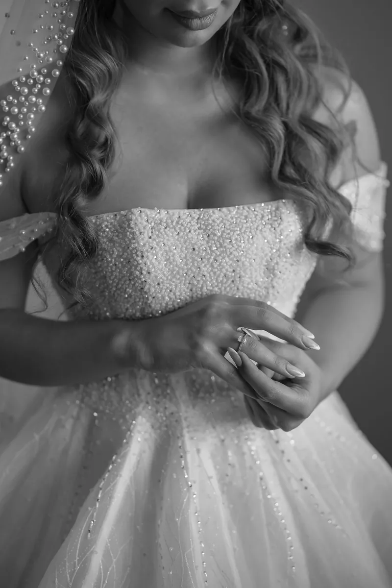 Bride in a beaded gown holding her hands at her waist